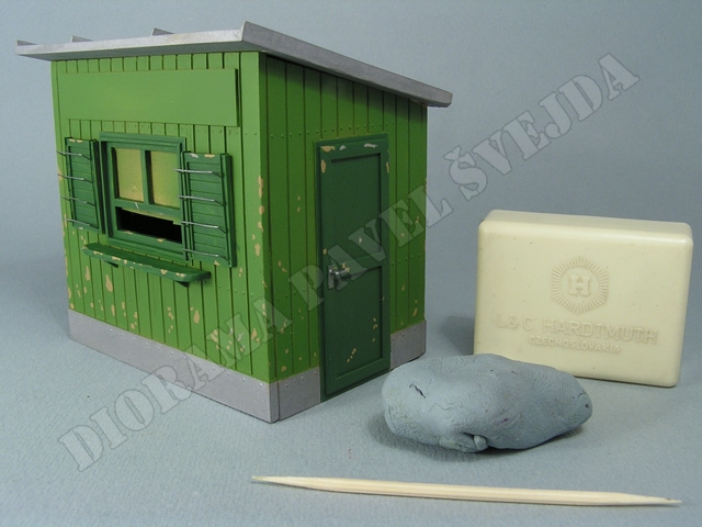 trafika7.jpg - P&aacute;r&aacute;tkem jsou prop&iacute;chnuty puch&yacute;řky vytvořen&eacute; Maskolem pod zelenou barvou a plastickou gumou je Maskol odstraněn bez po&scaron;kozen&iacute; kryc&iacute; barvy, t&iacute;m vznikly odřeniny &bdquo;na dřevo&ldquo;.